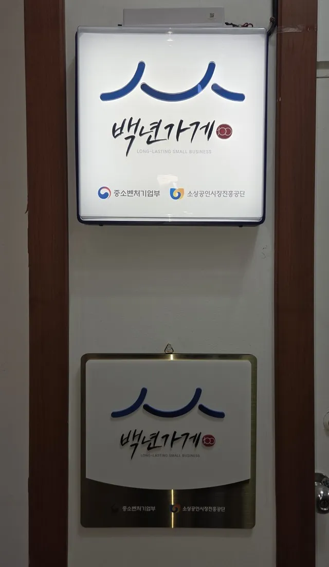 학원 벽의 백년가게 현판 두 점